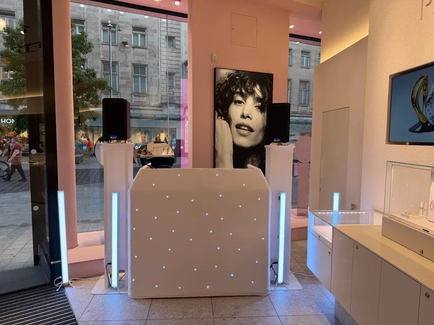 White MHX DJ booth and podiums with vertical light bars inside a Pandora store