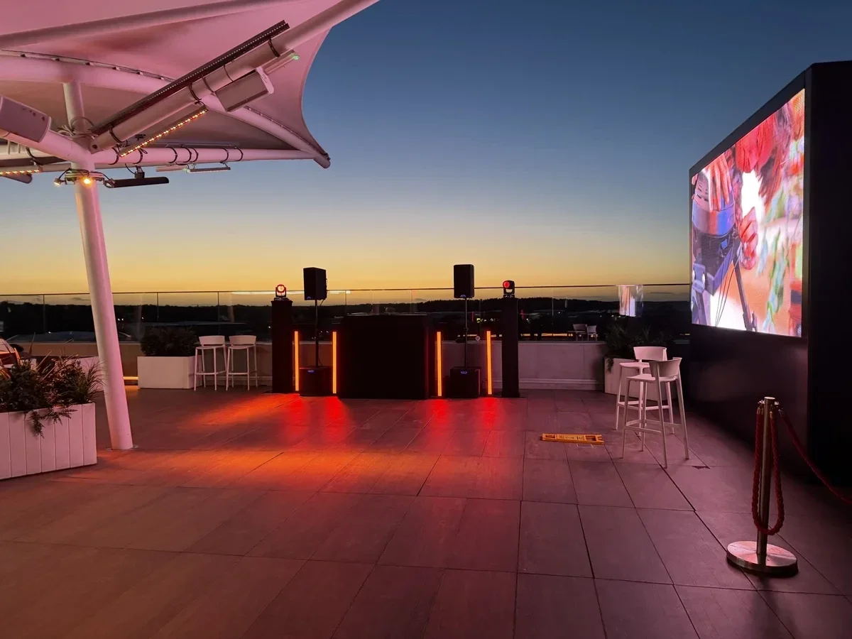 MHX DJ setup on the Hilton Garden Inn Silverstone rooftop at sunset for SimStaff’s anniversary event