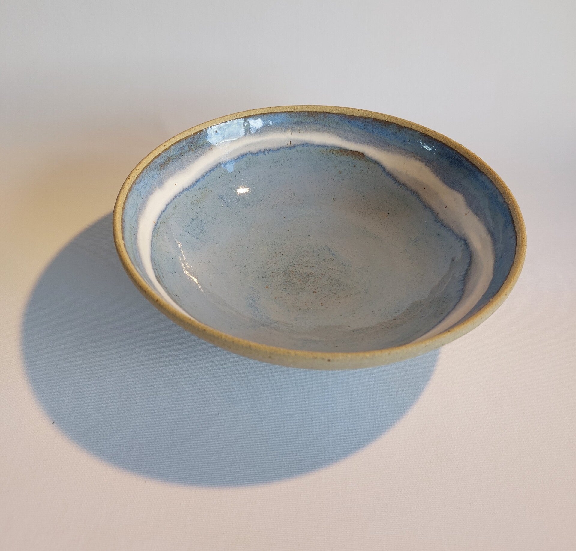 Schaal in een frisblauwe glazuur met witte boord