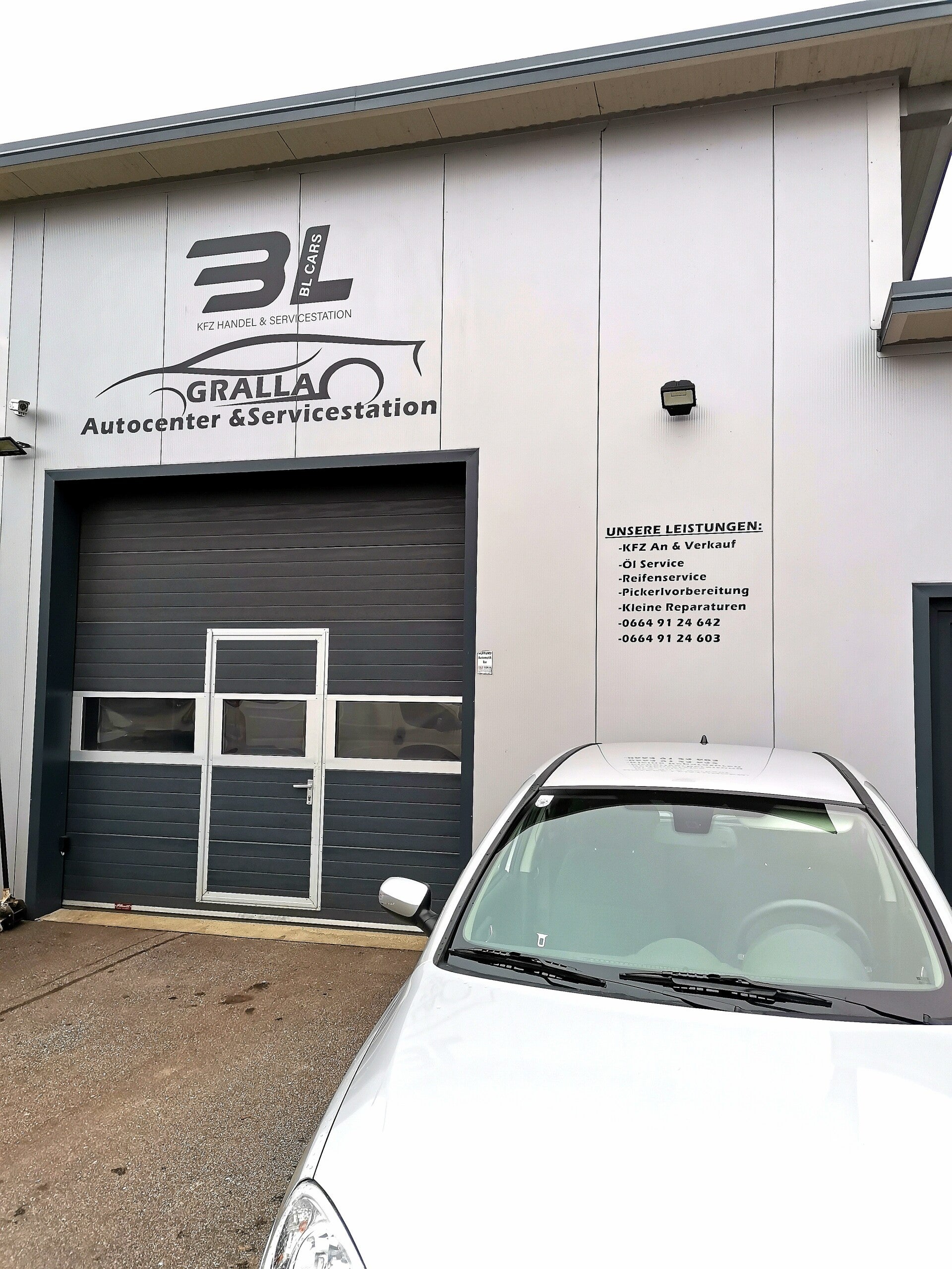 "Bild des Autocenter Gralla, bei dem AK Folien Firmenlogos an der Fassade angebracht hat, mit Folie von Avery in Schwarz. Erfahren Sie, wie unsere maßgeschneiderten Beschriftungslösungen Ihrem Unternehmen eine professionelle und ansprechende Präsenz verle