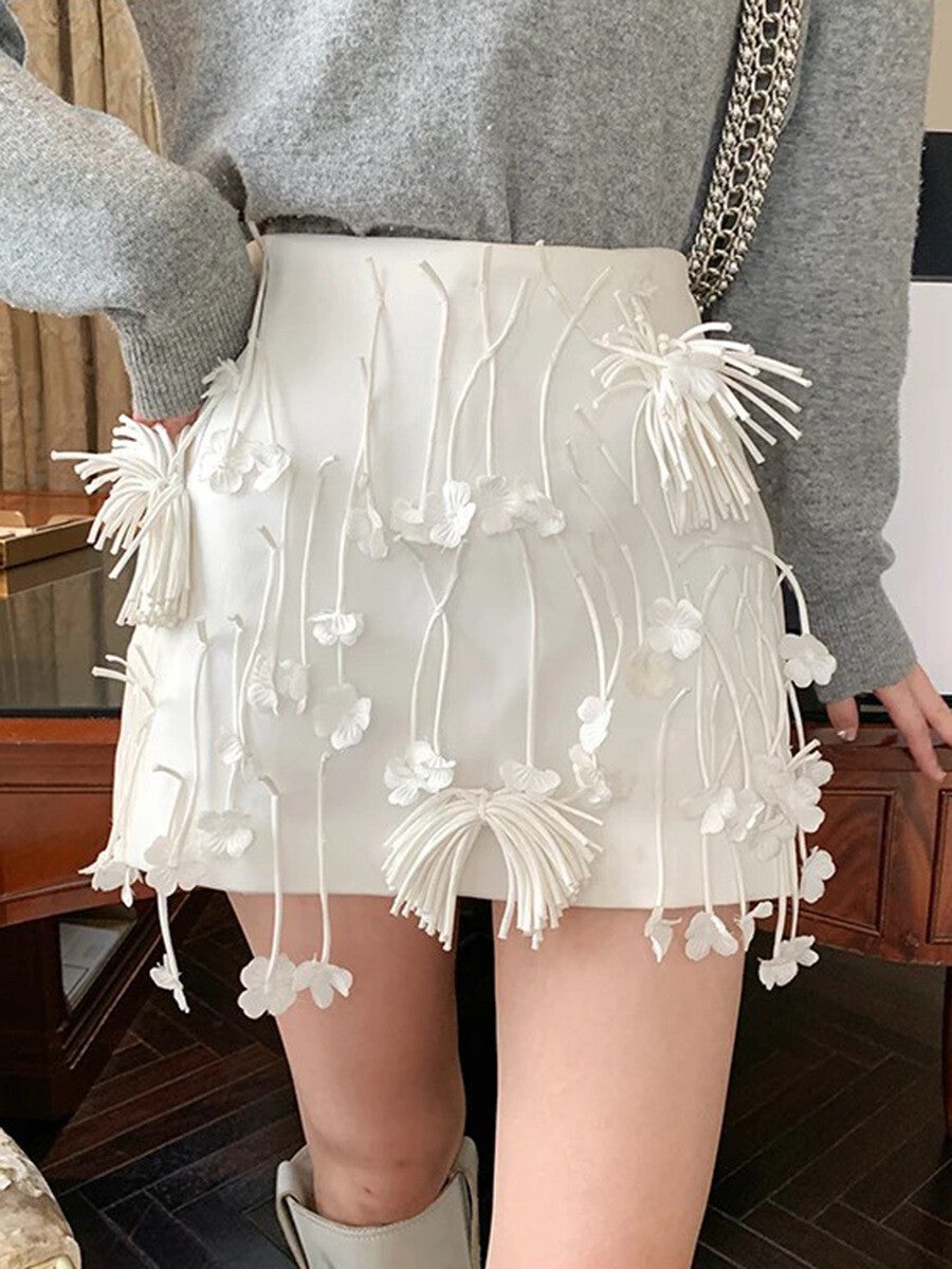 Jupe courte à pompons à la taille