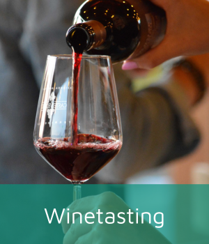 Bottle of red wine being pored into a wineglass.