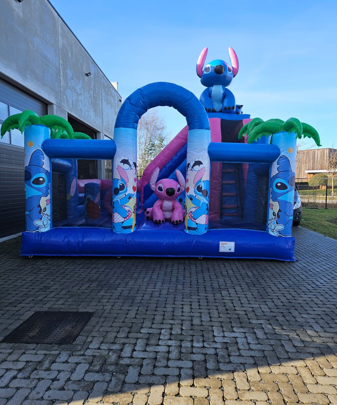 Populair Blue Rebel springkasteel met glijbaan in Hawaï-stijl, thema blauw buitenaards wezen huren in Genk en Limburg - Cosmo's Verhuur