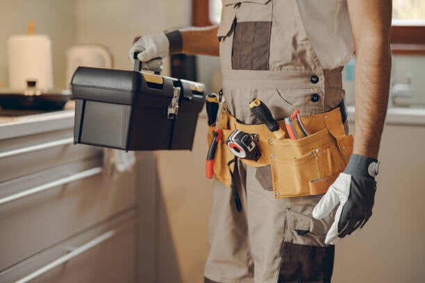 Handwerker mit Werkzeugkoffer für Arbeiten am Objekt