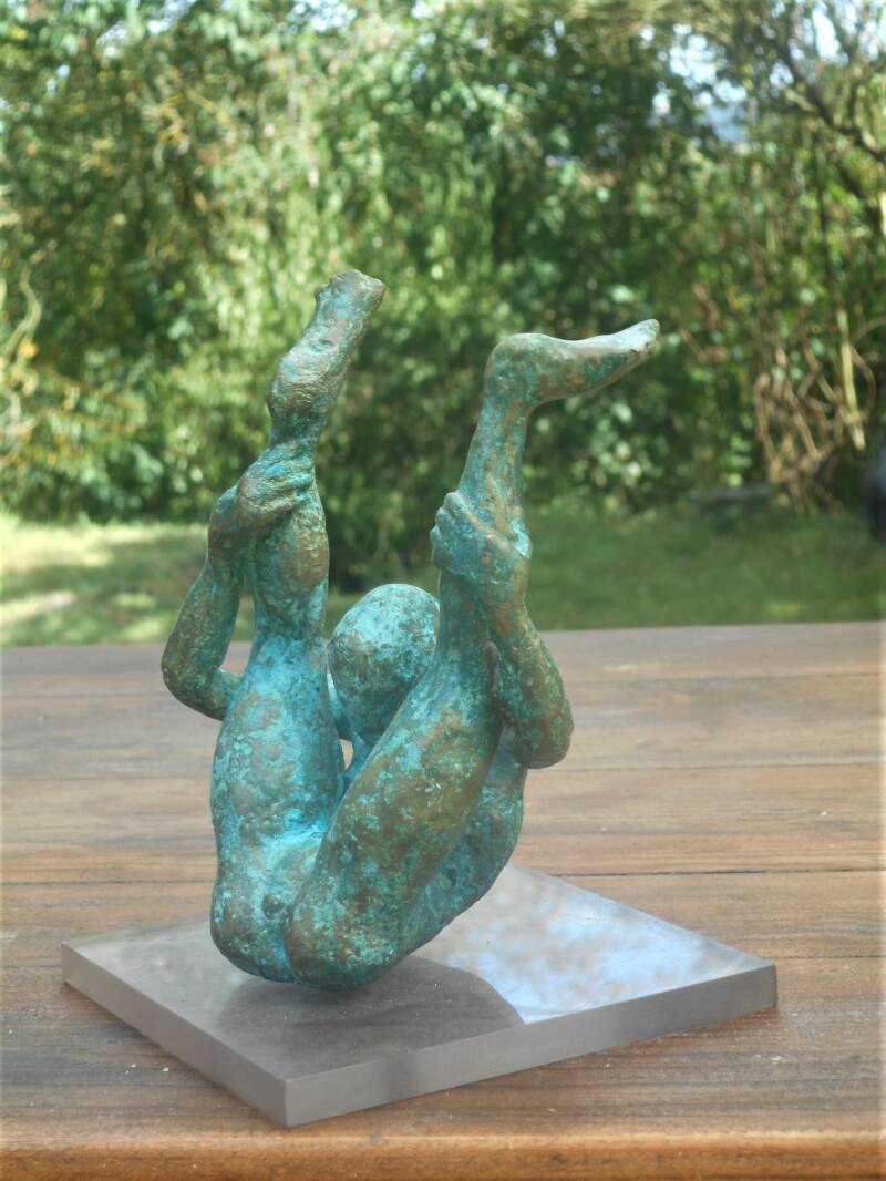 Bronze représentant une femme assise qui regarde entre ses jambes sont relevées