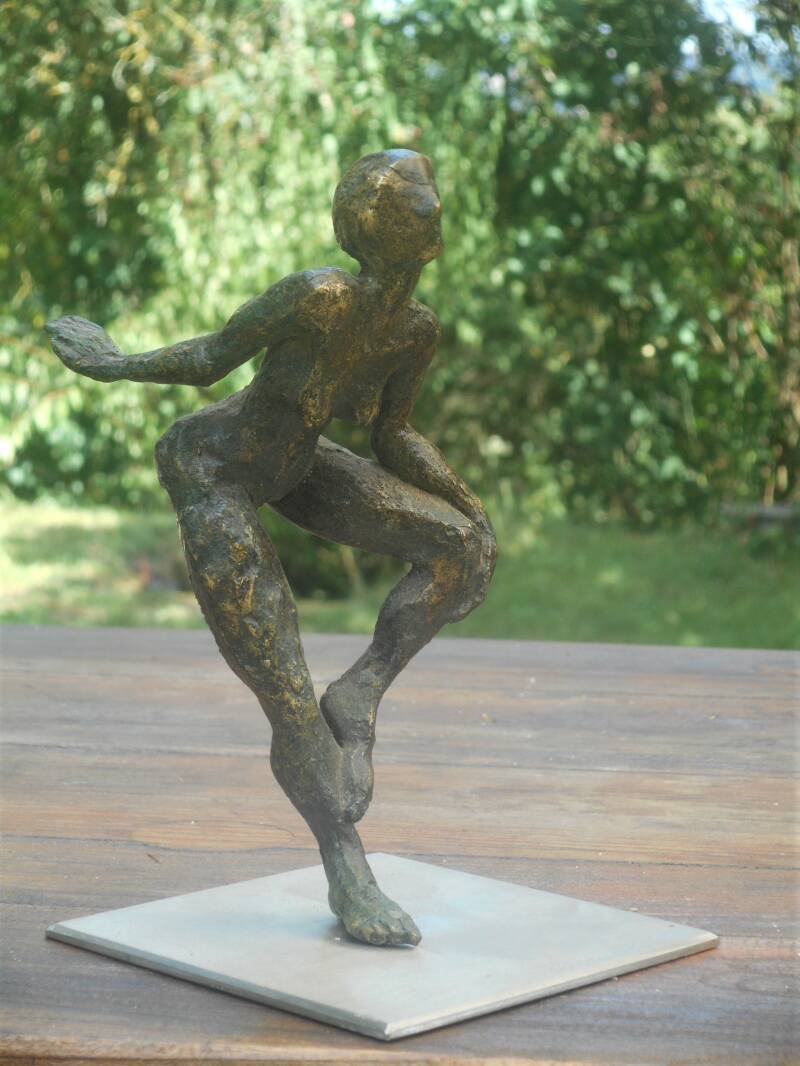 Petite sculpture en bronze d'une femme dans une posture espiègle.