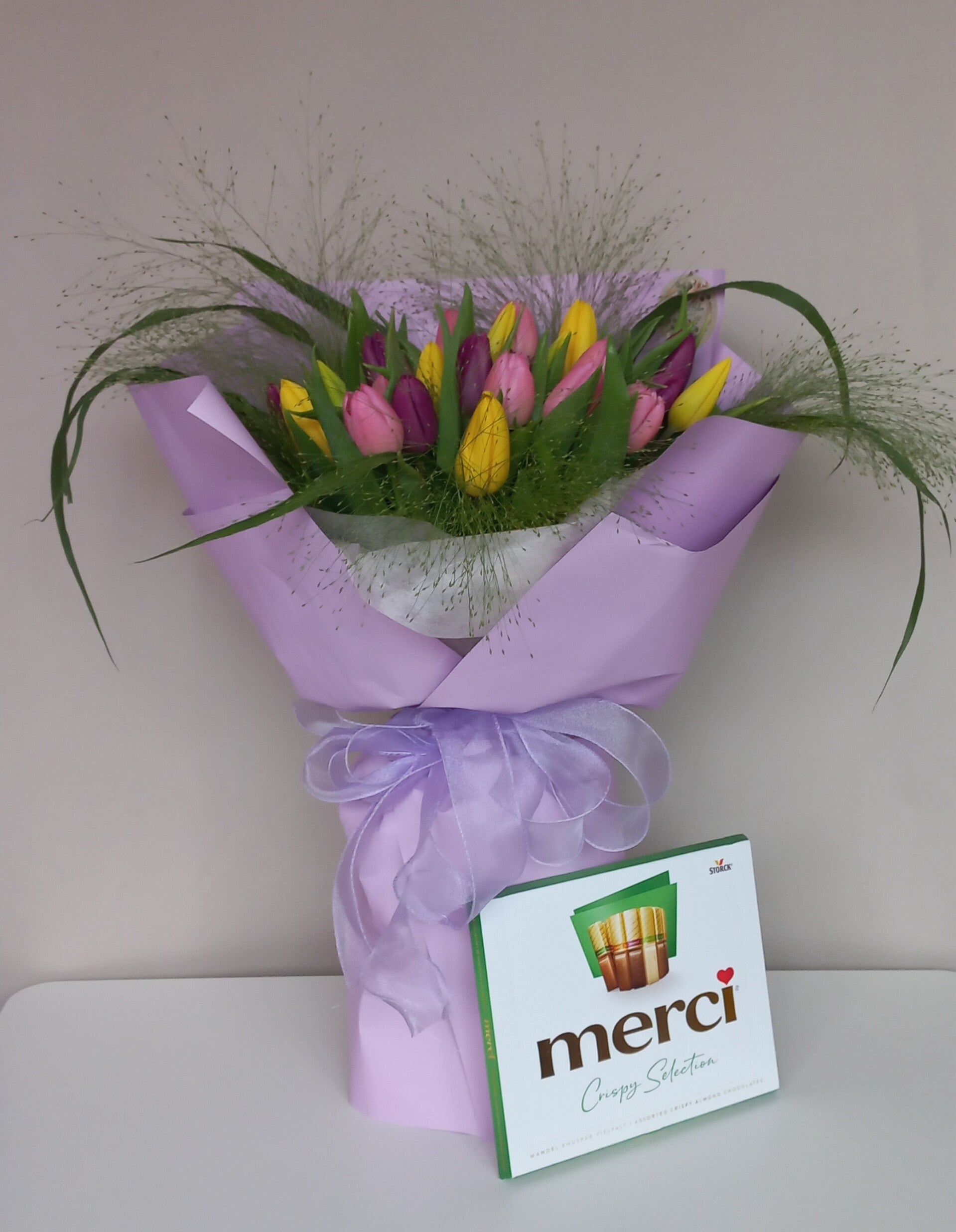 Een boeket tulpen met een cadeau (Merci-snoepjes)