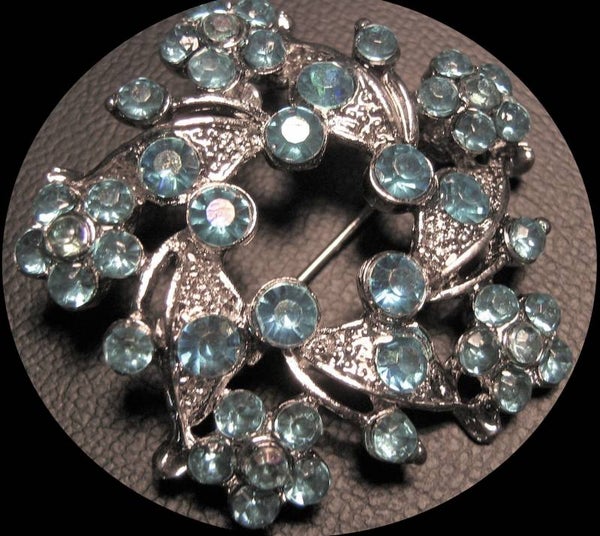 [11002]  Zilverkleurige bloembroche met blauwe strass