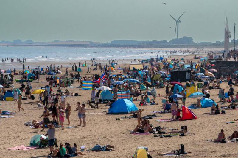 RNLI lifeboat crew on Bridlington beach responding to multiple incidents involving missing children and paddleboarders, promoting beach safety wristbands for families.