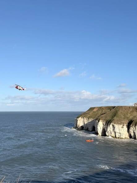 Coastguard helicopter and RNLI lifeboat during multi‑agency rescue at Thornwick Bay
