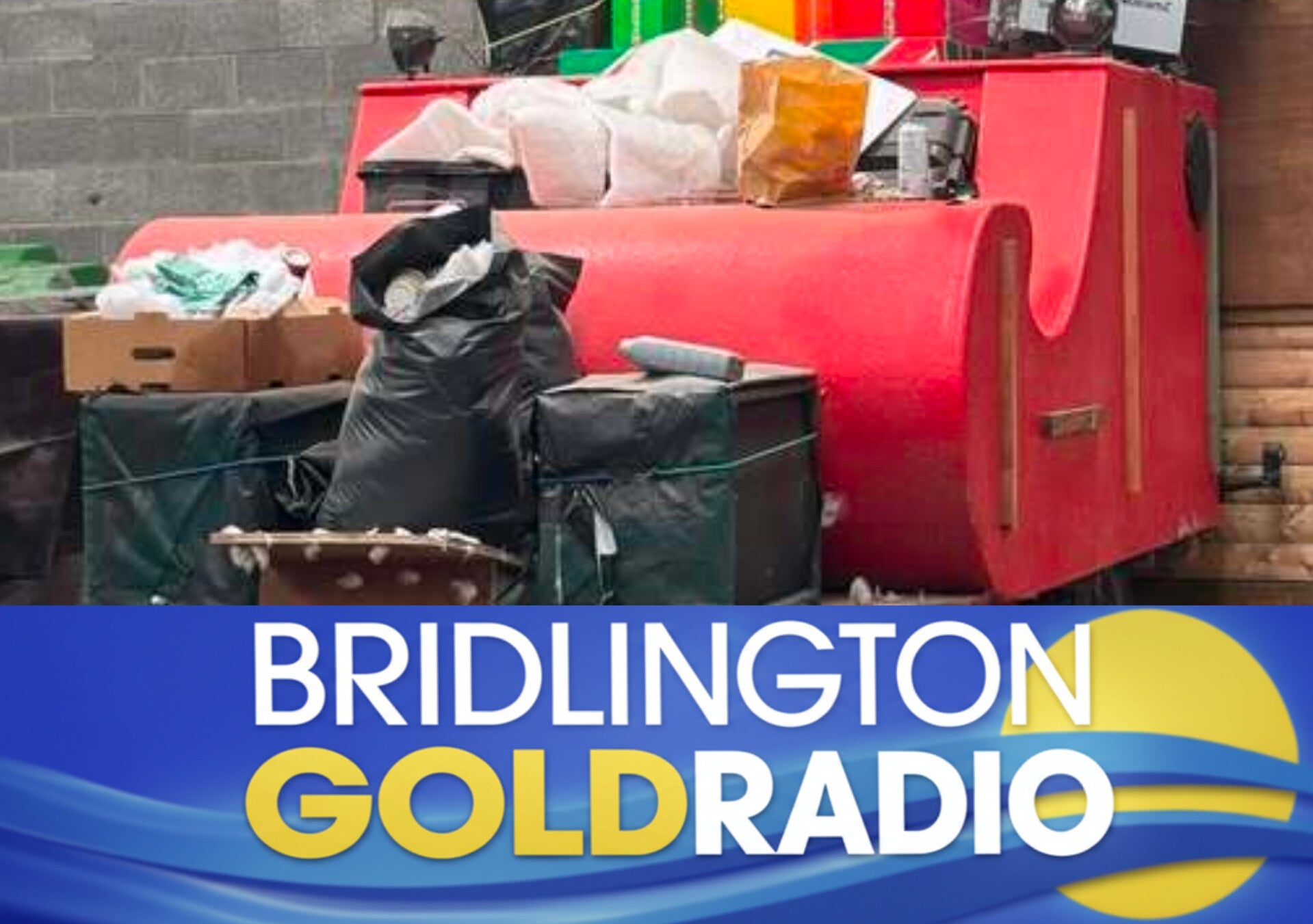 Bridlington Round Table’s Santa Sleigh pictured inside its storage unit after a break‑in, with bags and boxes piled around the bright red sleigh.