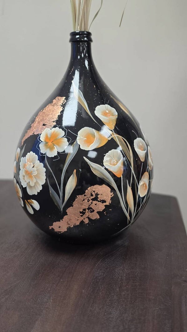 Grote zwarte vaas met rosegoud en witte bloemen