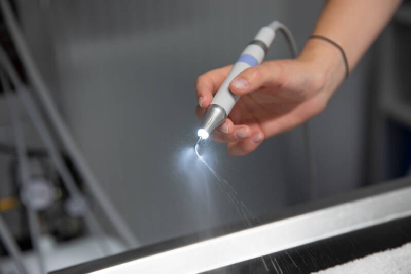 Hand met instrument tandarts met lampje Bedrijfsfotograaf Heidi Rombouts.jpg