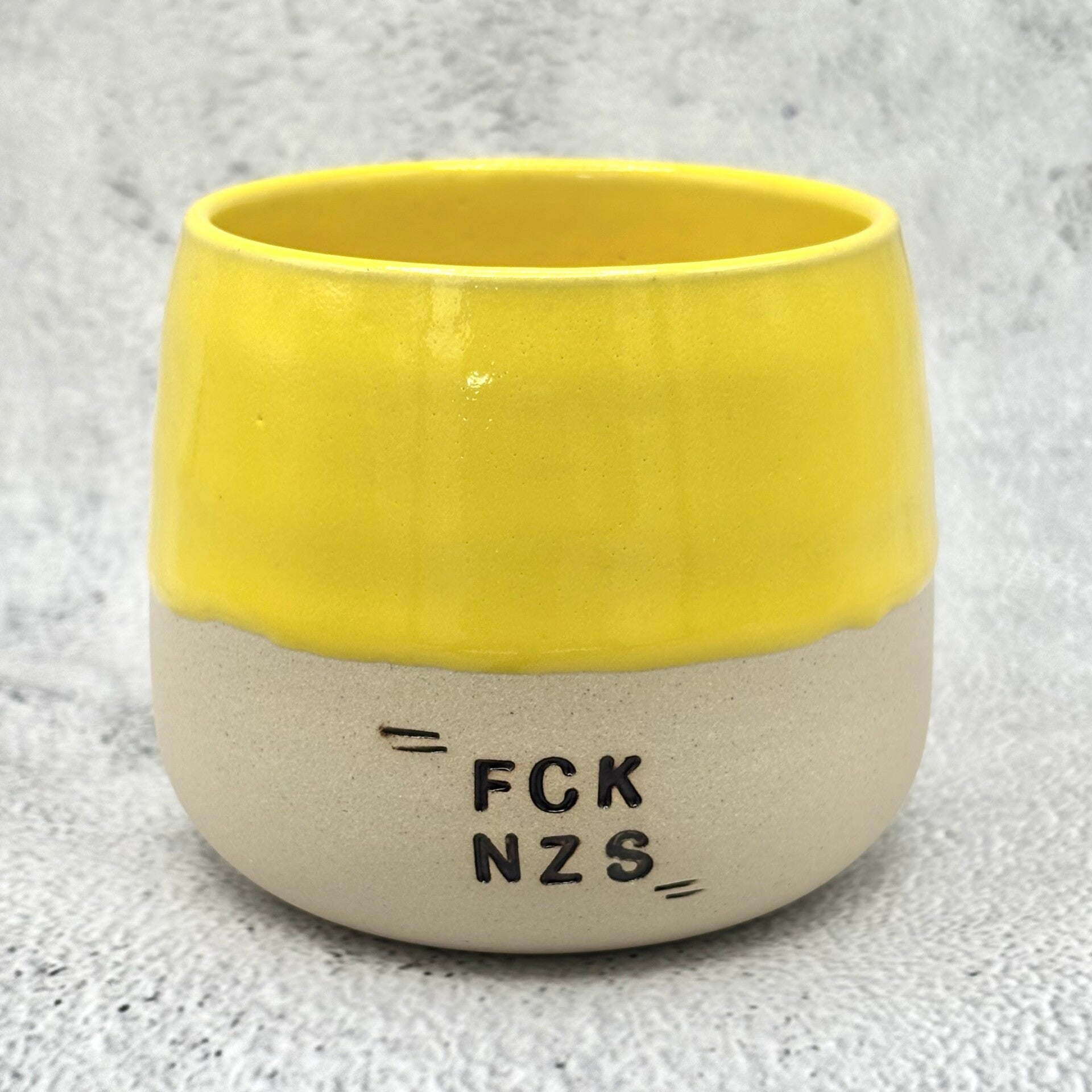 Keramiktasse mit Statement – FCK NZS in Beige und Gelb