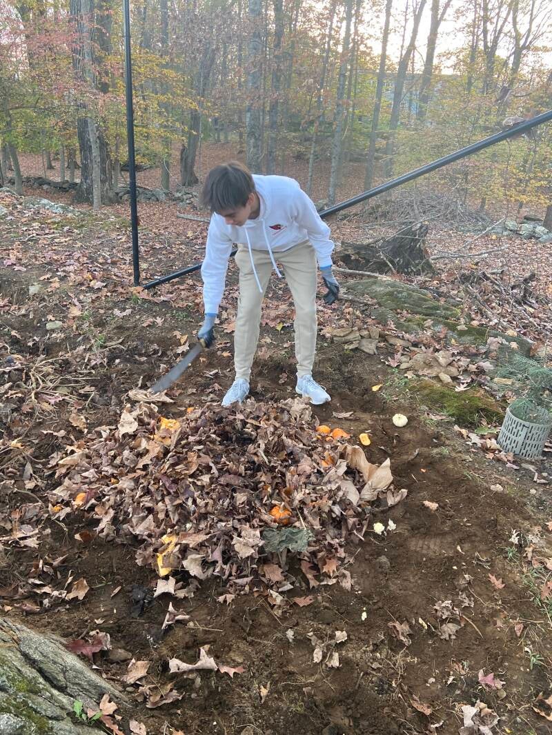 Addison Towle breaking up compost into smaller pieces - Greenwich Composting Project