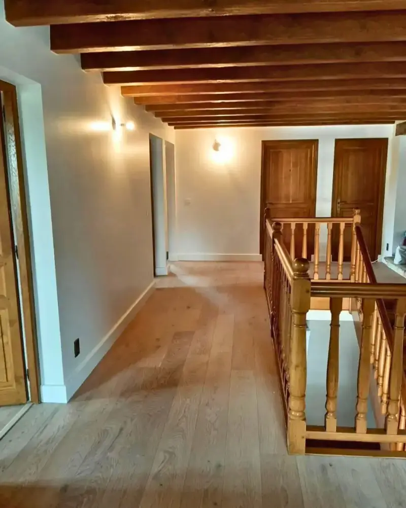 Pose collée d'un parquet chêne sur plancher chauffant dans un couloir à Thusy