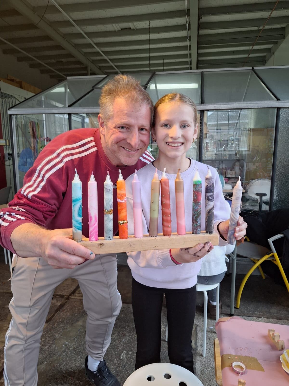 Vader en dochter tonen hun zelfgemaakte kaarsen