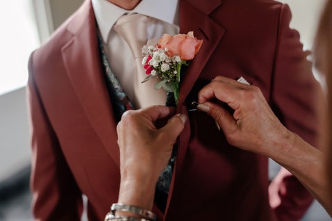 Ceremoniemeester speld corsage op