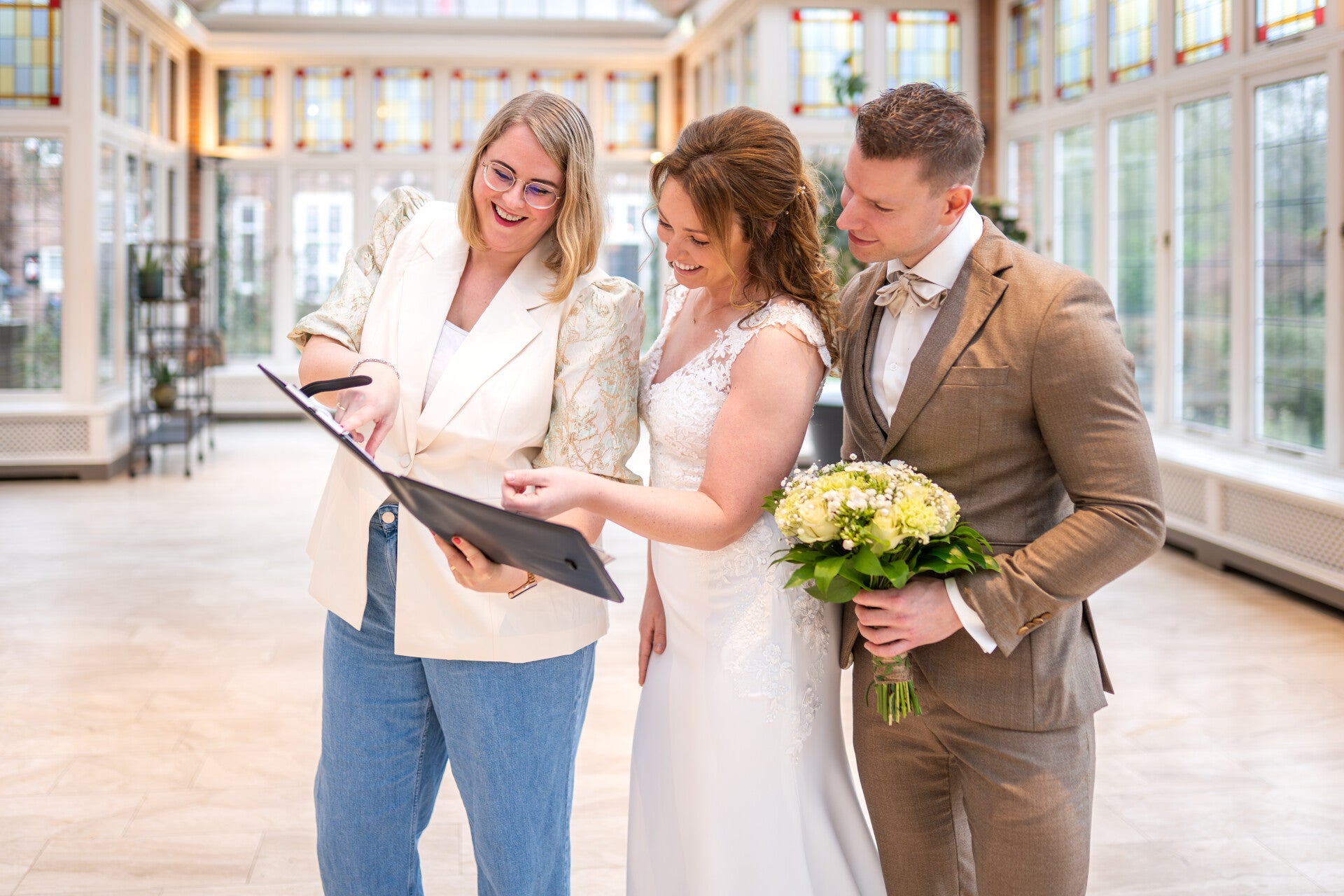 Ceremoniemeester kijkt samen met bruidspaar in draaiboek