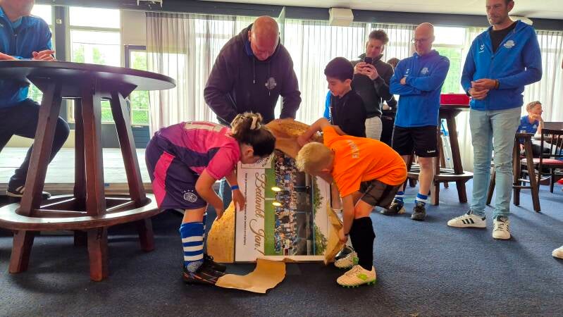 Twee van zijn pupillen helpen bij het uitpakken