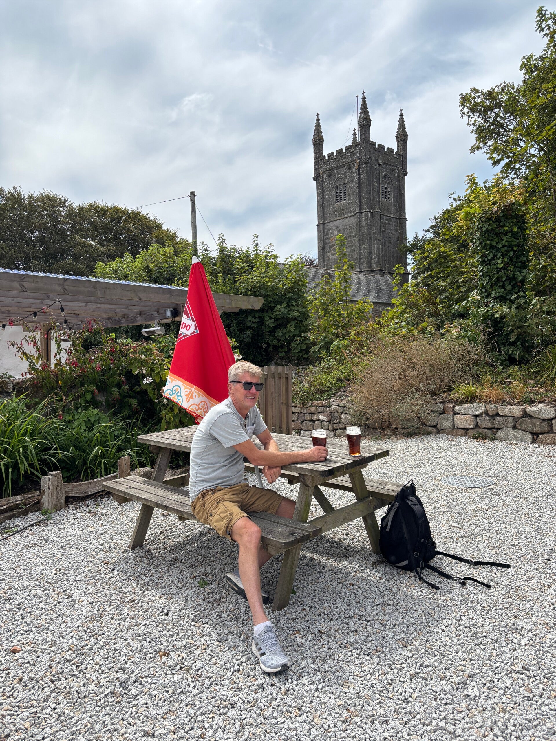 Treeve Thomas enjoying a pint with Ludgvan Church behind