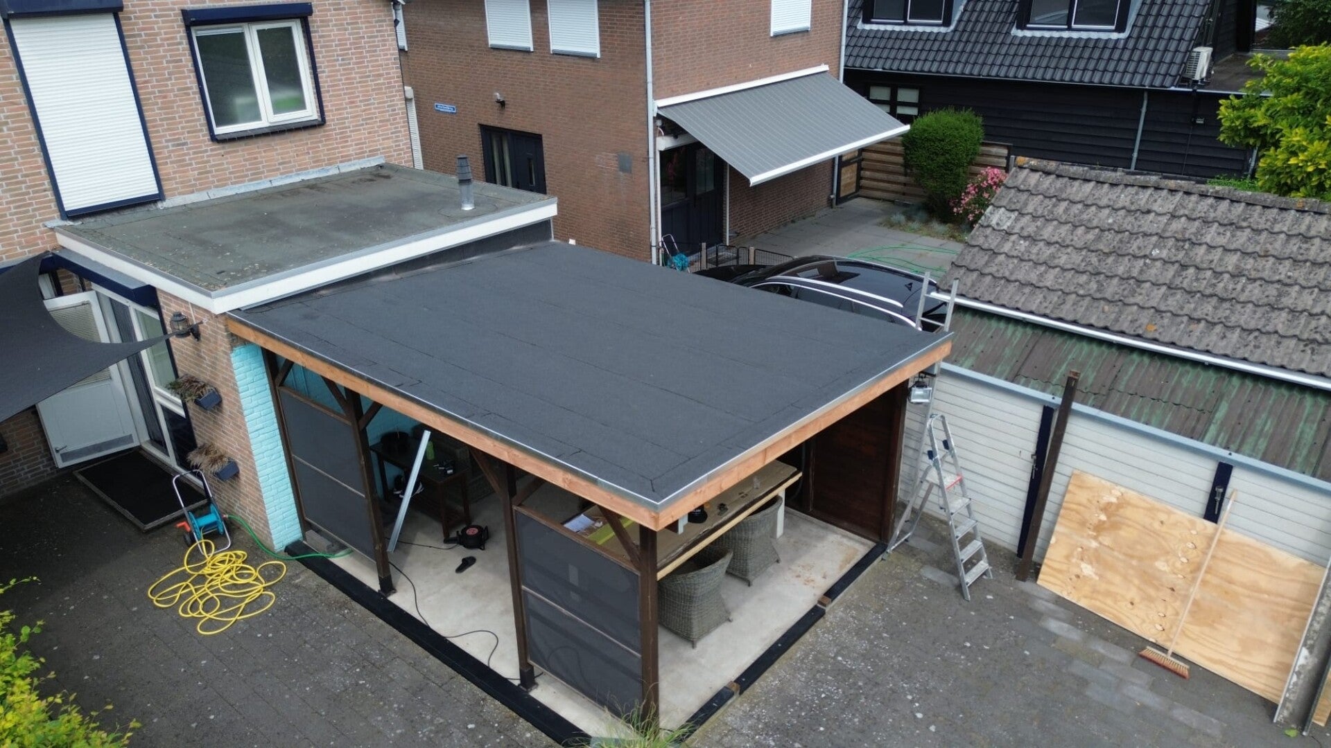 Nieuwe bitumen dakbedekking op het platte dak van een aanbouw, aangebracht door Mersch Dakbedekking
