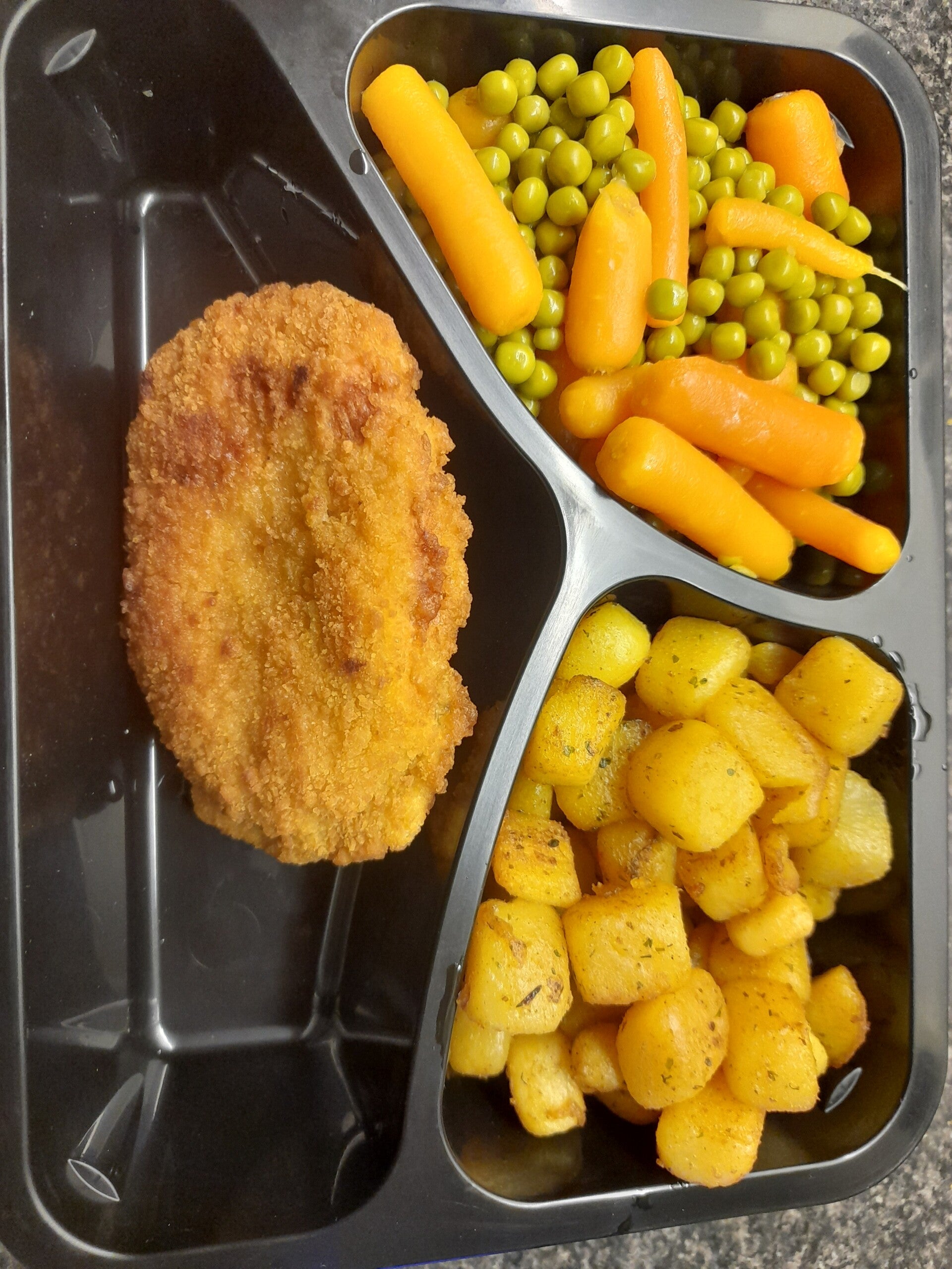 Pee en erwtjes gebakken aardappelblokjes en varkenschnitsel