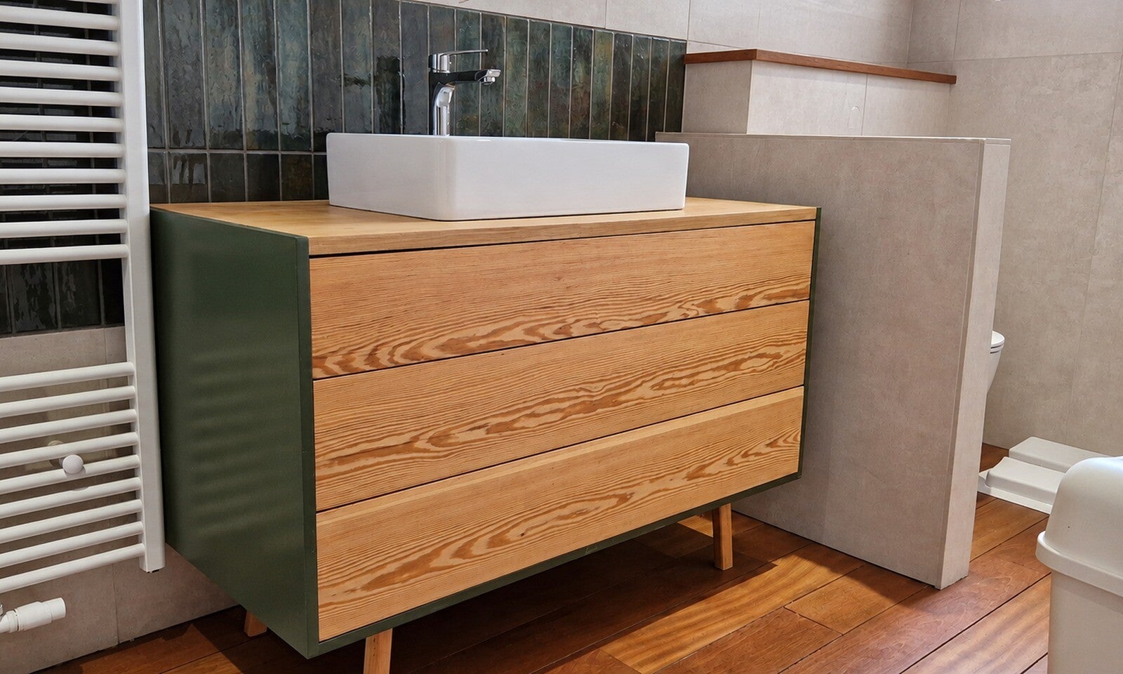 Meuble vasque avec façade en bois au veinage marqué, côtés vert profond et vasque à poser