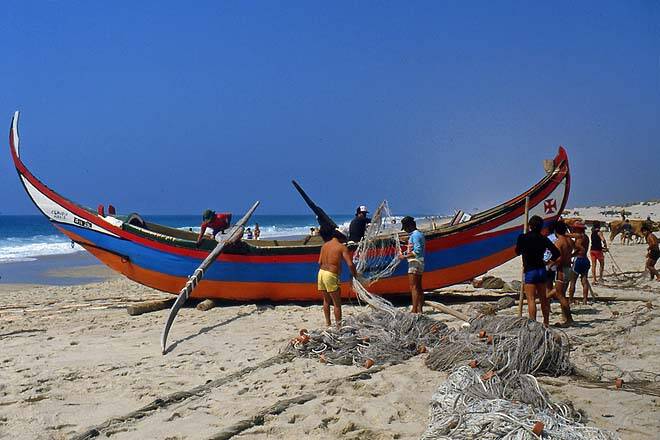 Um barco de perca na praia da Torreira em Portugal. Percadores a volta do barco