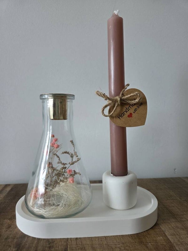 Vaasje met droogbloemen met kaars op schoteltje