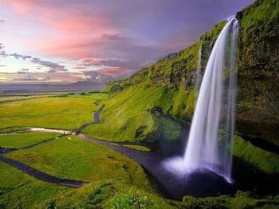 Delayed ejaculation - a waterfall cascading over a cliff edge into a river that winds through a grassy valley 