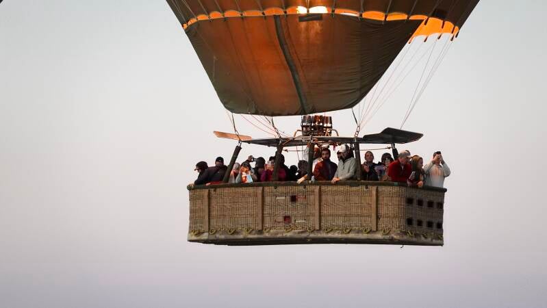ballonvaarders in luchtballon kijken om zich heen