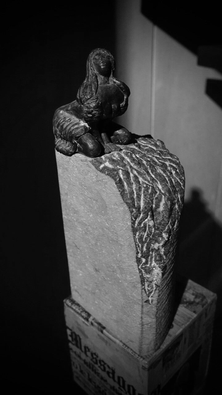 bronzen beeldje van geknielde sensuele vrouw op arduinen sokkel