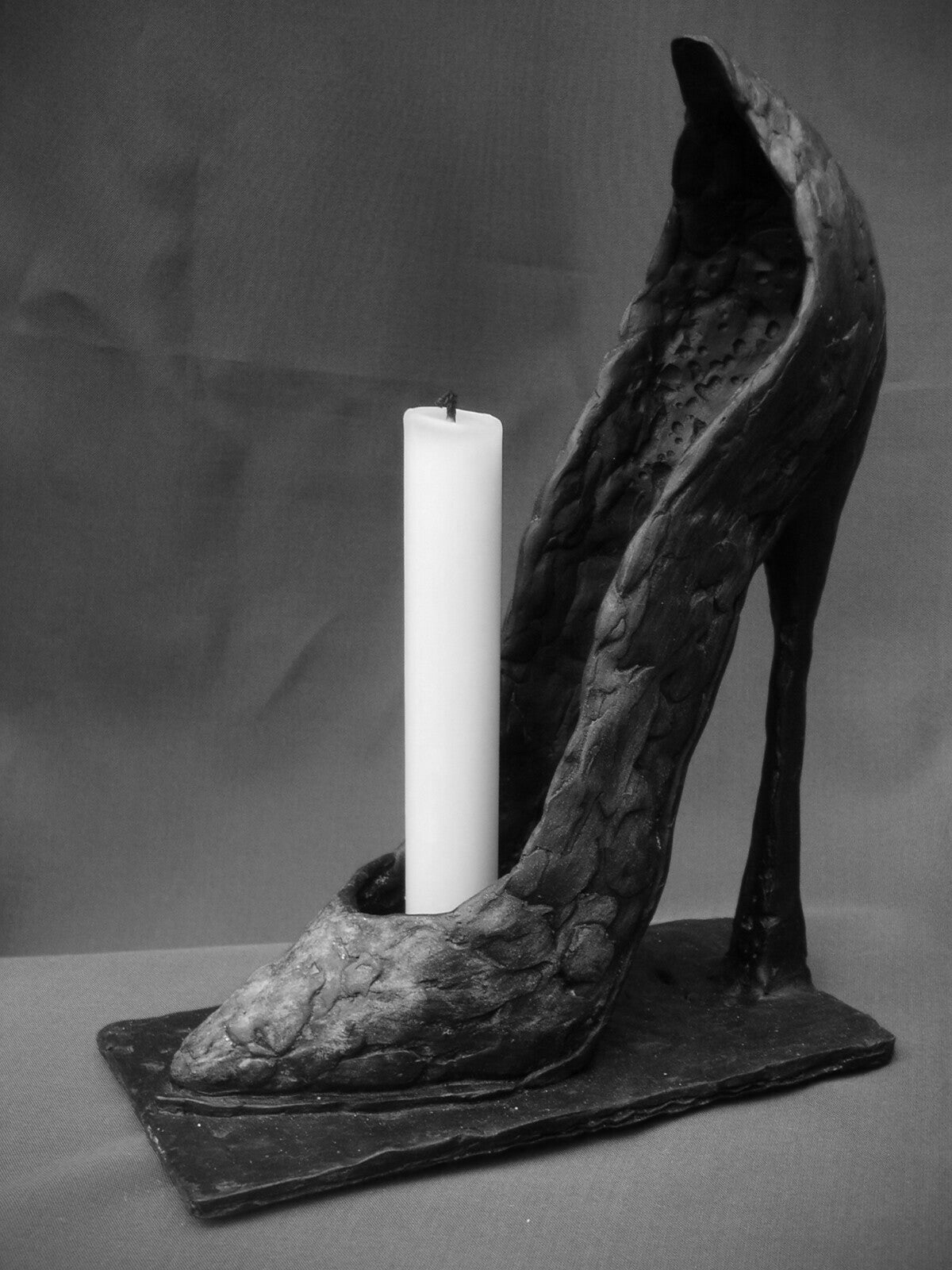 bronzen beeldje van hooggehakte vrouwenschoen (high heels)  als kaarsenstandaard