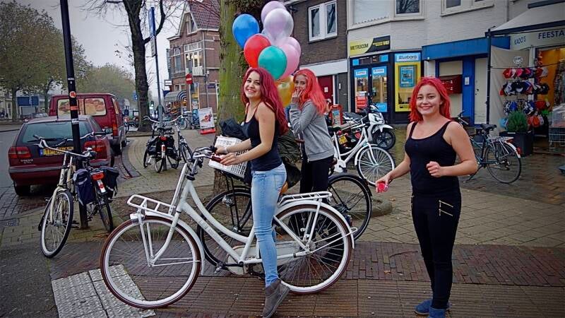 vrolijke meisje met rood geverfde haren en ballons op Stationsplein Alkmaar