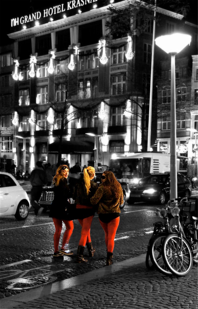 3 meisjes met rode broek 's-avonds op de Dam in Amsterdam