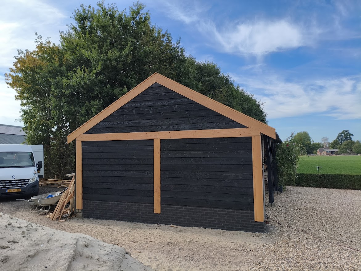 Een zwarte carport met details van bruine balken
