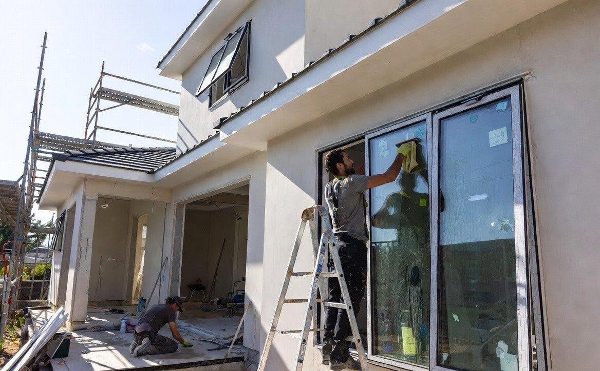 2 cleaners on a build site cleaning the windows and the floor tiles