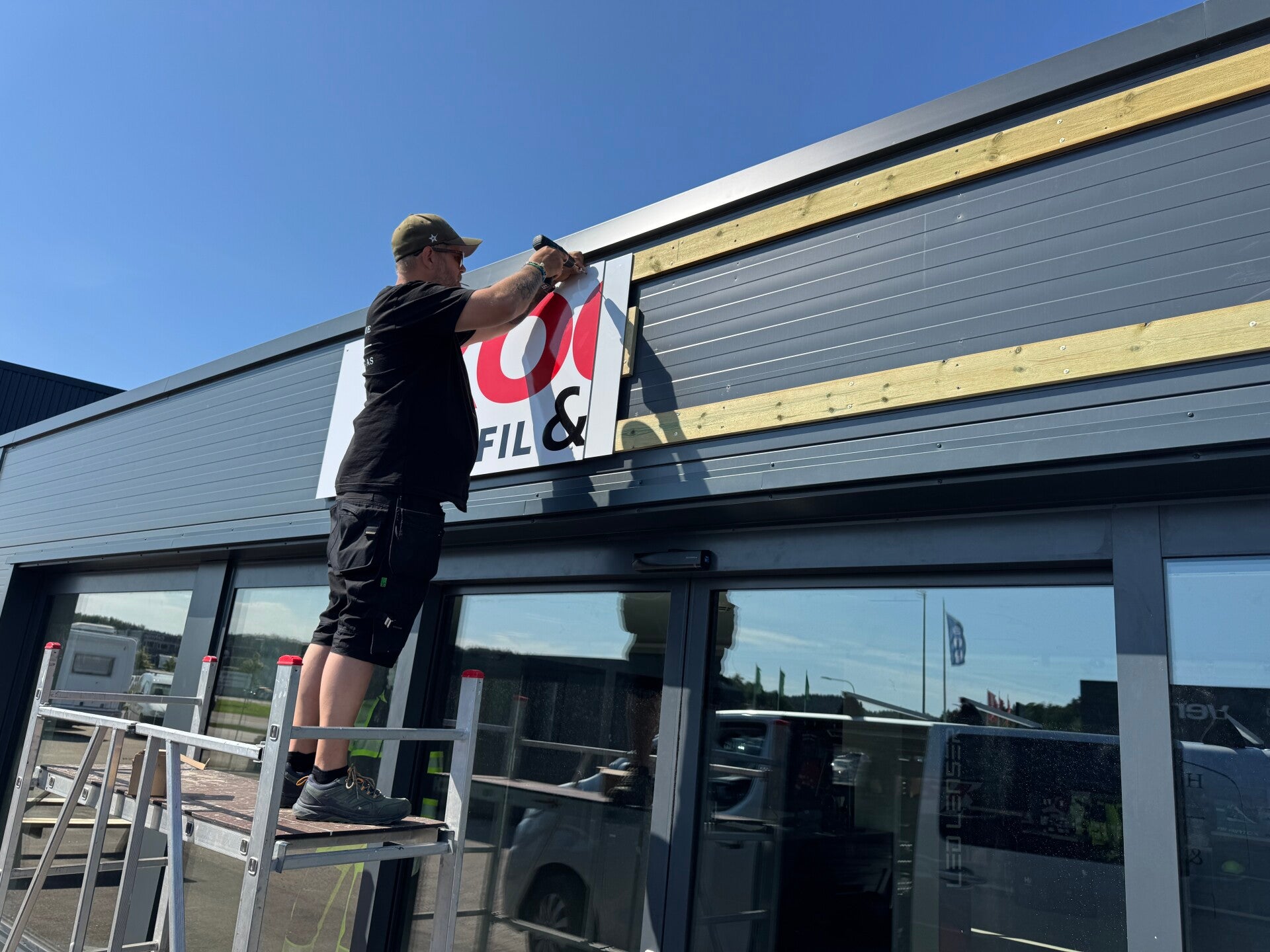 Fasadeskilt under montering på yttervegg