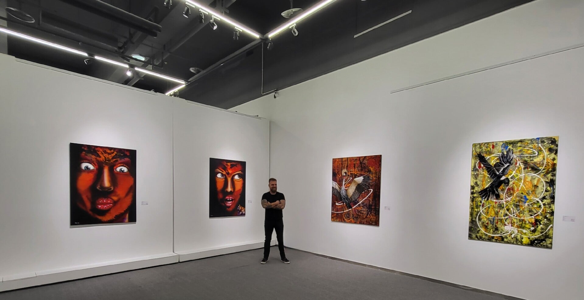 Willem Vos standing among his paintings at Hong Art Museum in Chongqing during Transcendence.