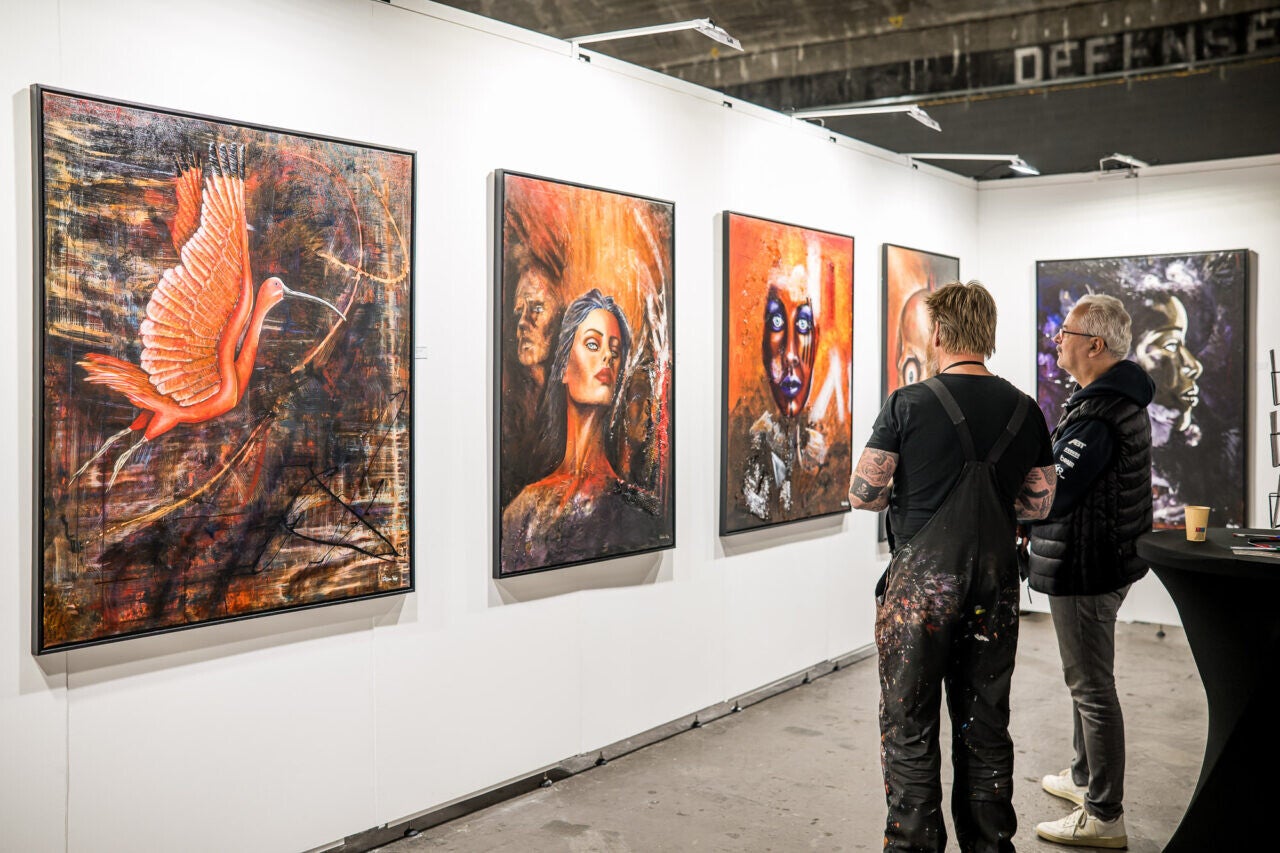 Visitors viewing a large painting by Willem Vos during an exhibition in Dwingeloo, the Netherlands.