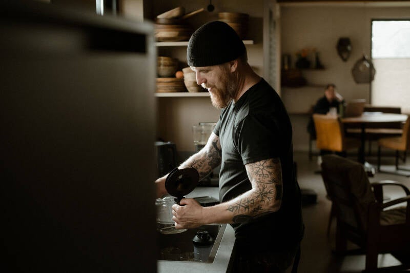 Artist Willem Vos preparing coffee before discussing a commissioned painting.