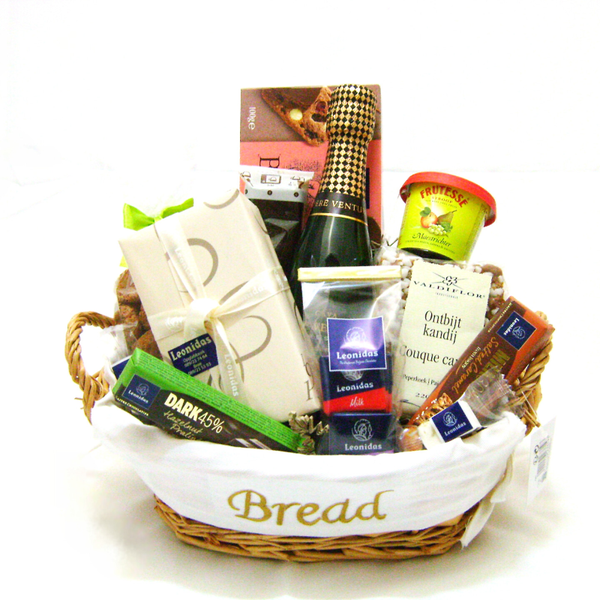 Broodmand gevuld met een doosje pralines, cava en allerlei lekkernijen