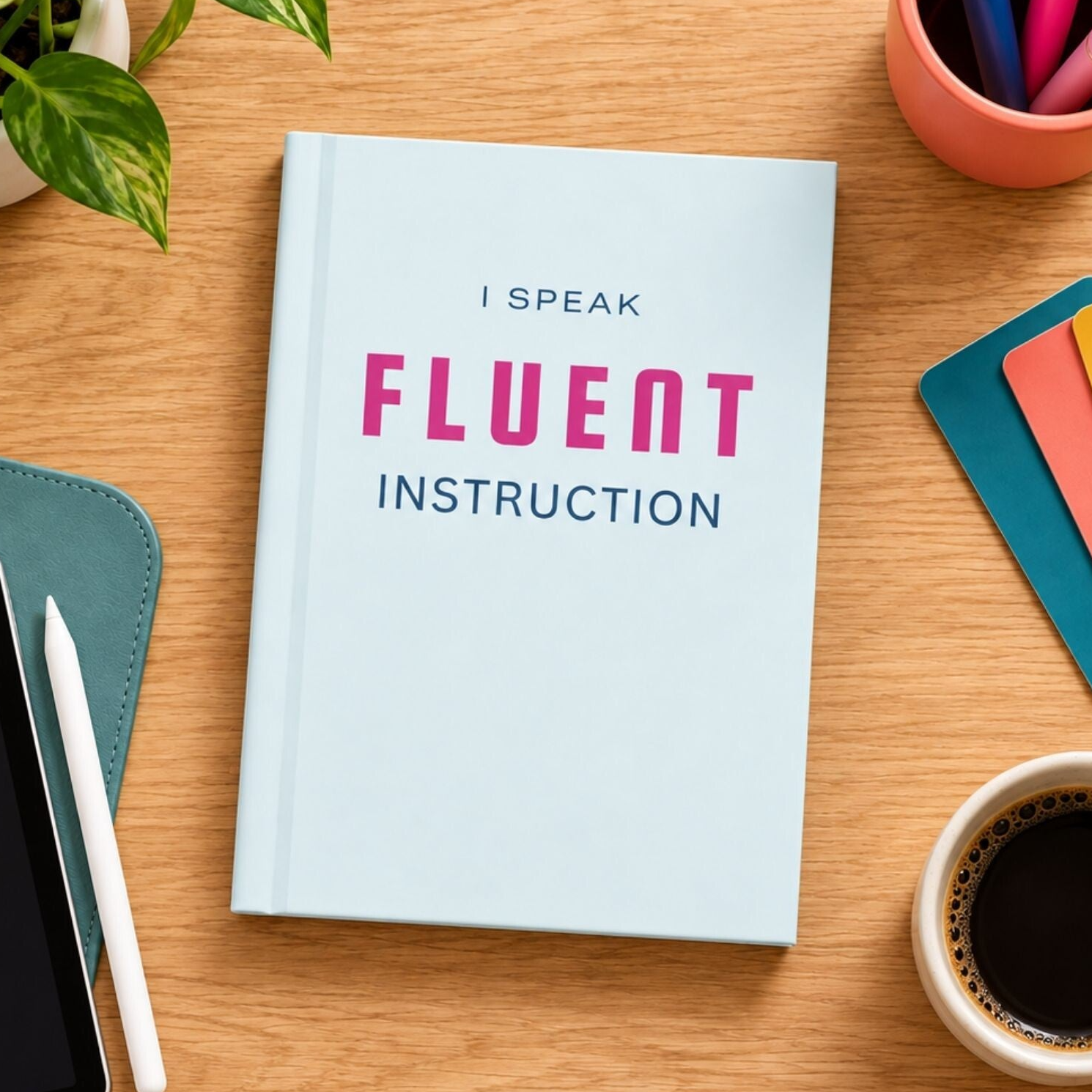 Light blue hardcover journal in a colorful office workspace with desk accessories and a cup of coffee.