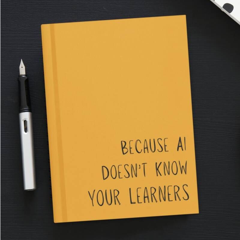 Mustard yellow hardcover journal on a black desk with a pen on the left side.
