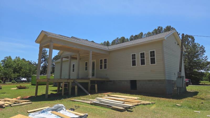 Another perspective on the craftsmanship: porch posts, roof transitions and window trim bring the exterior design together. / Otra perspectiva del trabajo: postes del porche, encuentros del techo y molduras de ventanas que integran el diseño exterior.