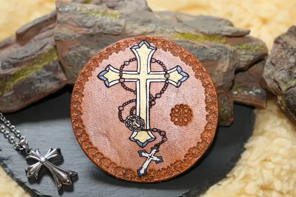 Handgefertigter Lederuntersetzer mit einem Kreuz als Motiv