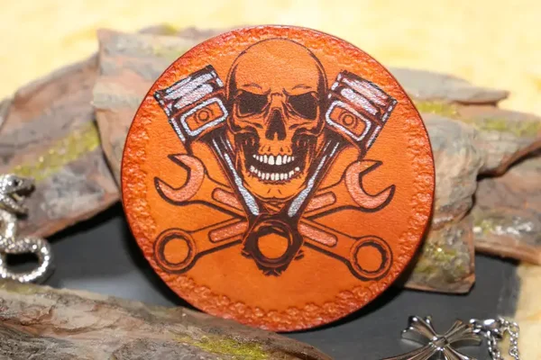 Handgefertigter Lederuntersetzer mit Totenkopf und Motorkolben als Motiv