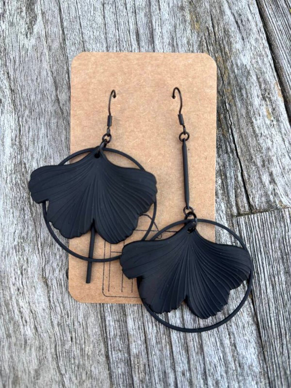 Zwarte hanger met ginkgo blad en zwarte cirkels.