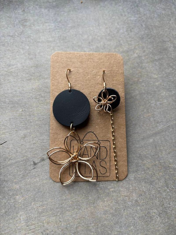 Goudkleurige bloem-hangers met zwart leer.